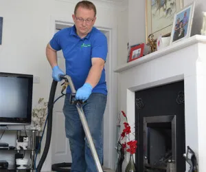 David Roberts in the process of cleaning a carpet rug